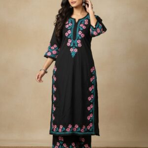 Woman wearing a black rayon straight kurta pant set featuring vibrant pink floral and turquoise embroidery along the neckline, sleeves, and pant hem