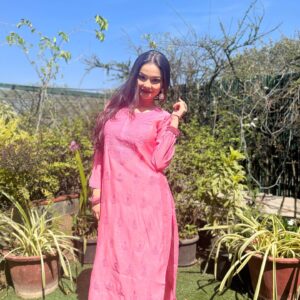 Woman standing outdoors in the sun wearing a vibrant pink Chanderi dyeable Chikankari style embroidered kurti with matching palazzo pants set