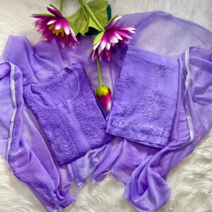 Flat lay of a light purple lavender Chikankari kurta set featuring fine hand embroidery on the top and pant hems, accompanied by a matching chiffon dupatta with white lace trim and pink floral props.