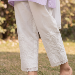 Women wearing a white cotton Chikankari lace pant in a garden setting